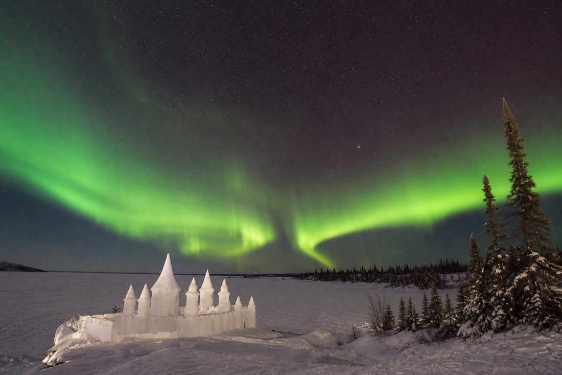 Snow castle rising from the frozen surface of Yellowknife Bay during a bright March afternoon