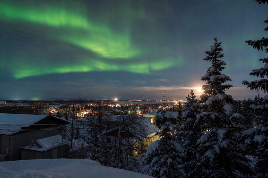 Winter sunrise at nearly midday over snow-covered rooftops in downtown Yellowknife