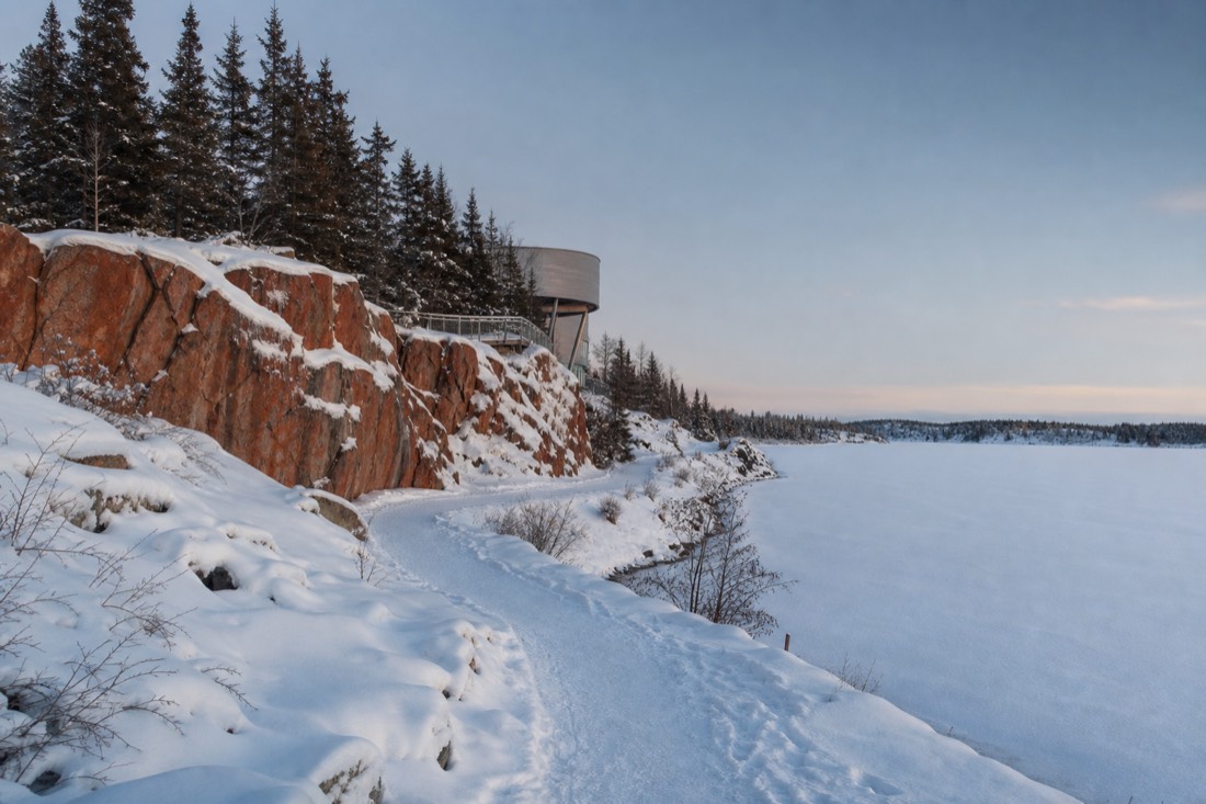 Snow-covered Frame Lake path beside the Prince of Wales Northern Heritage Centre in Yellowknife under pale winter afternoon light