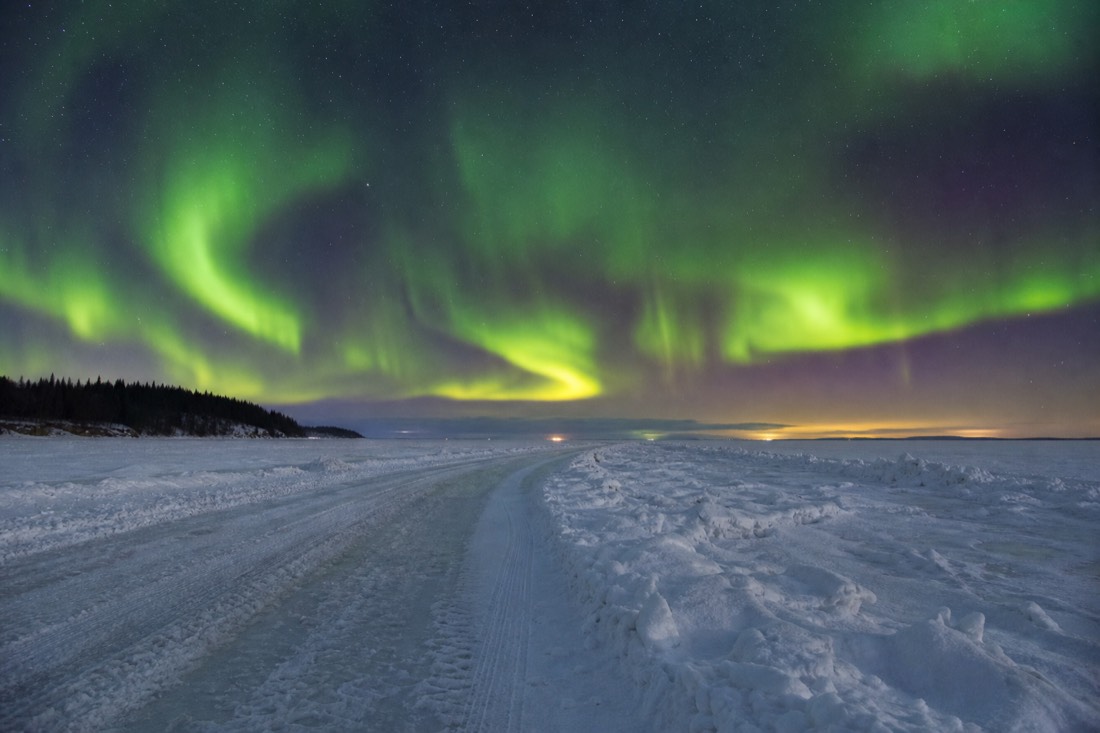 Plowed ice road stretching across frozen Great Slave Lake with pressure ridges and distant shoreline