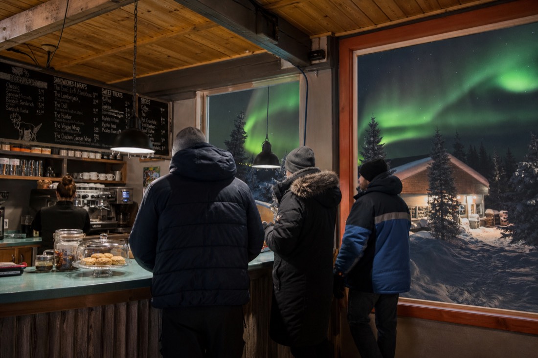 Cafe counter in Yellowknife with a menu board and travelers ordering in relaxed conversation