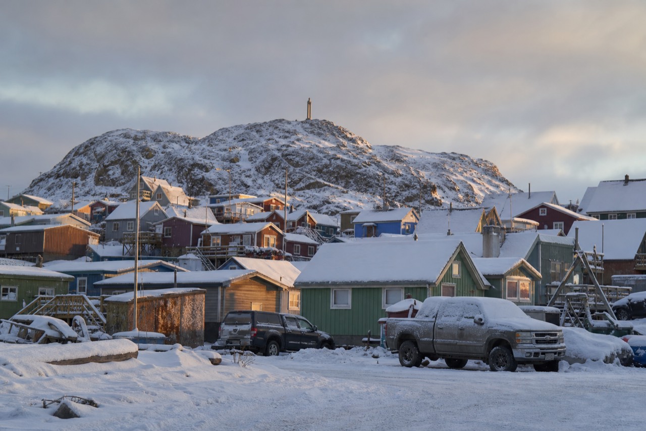 Colourful wooden buildings of Old Town Yellowknife in winter with snow and a pale northern sky
